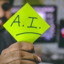 Business professional holding sticky note with Artificial Intelligence "AI" written on it