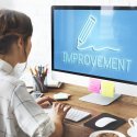 Woman in front of computer with "improvement" written on the screen
